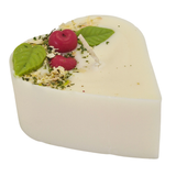 Heart-shaped candle with wax cherries and green leafs on a white background