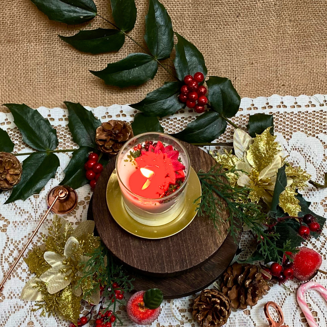 Small glass Winter Poinsettia candle lifestyle shot styled for Christmas home décor with Hollyberry fragrance