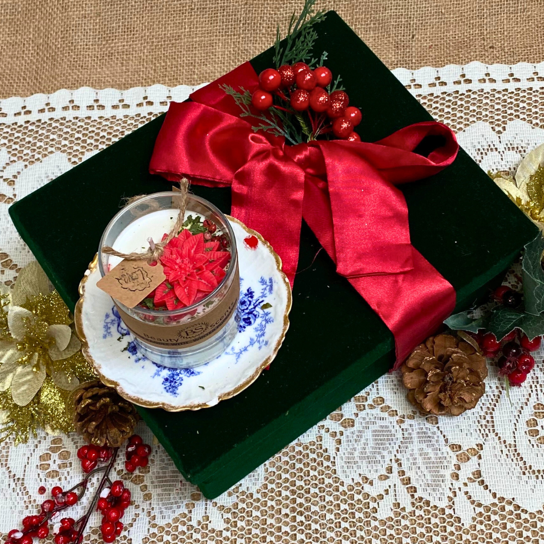 Small glass Winter Poinsettia candle side view showing white wax with festive botanical decoration