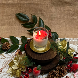Small glass Winter Poinsettia candle top view with red poinsettia flower arrangement on white wax