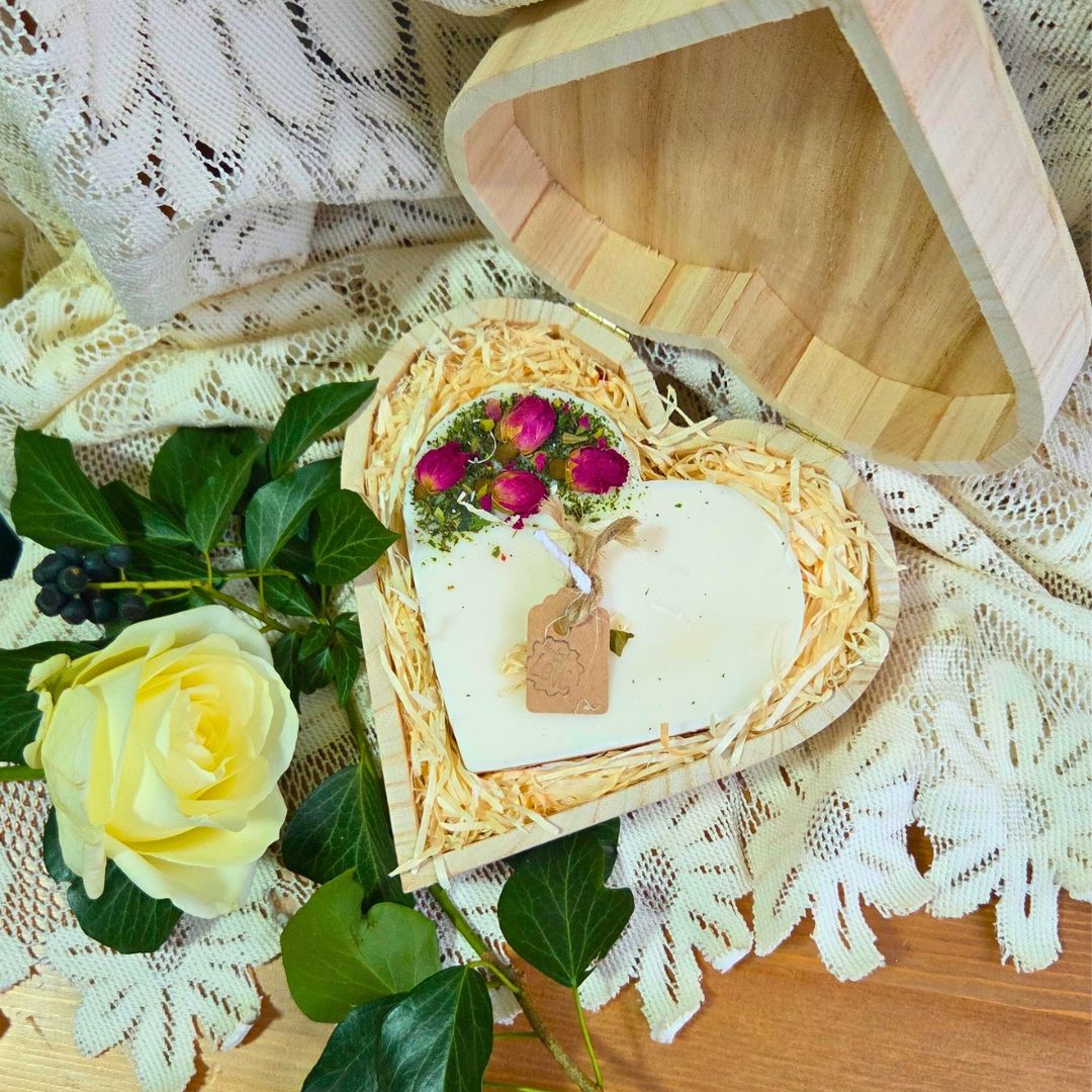 Top view of heart candle with rose buds in a wooden gift box
