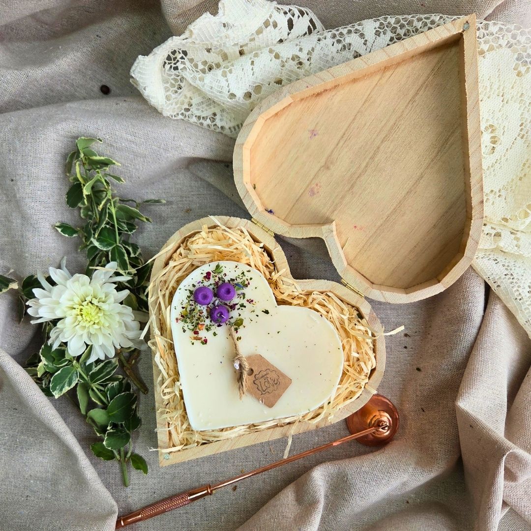 Large heart-shaped candle with blueberry decorations in a wooden heart gift box