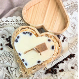 Top view of large heart candle in wooden box, featuring coffee bean decoration