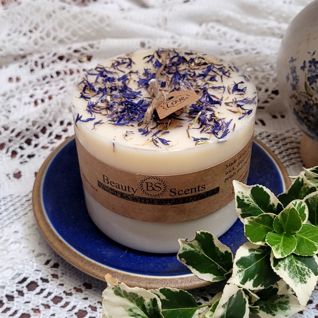 Large Wild Flowers soy candle 700g with blue cornflowers decoration on blue ceramic plate, styled with white lace doilies and fresh foliage - rustic lifestyle photography