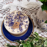 Candle with dried flowers on a blue plate with a lace tablecloth