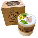 Candle with decorative elements and 'BS Beauty Scents' packaging on a white background