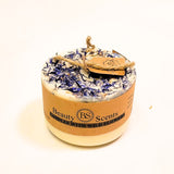 Candle with wildflower petals and 'Beauty Scents' label on a white background