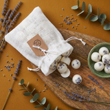 White drawstring bag with Beauty Scents wax melts lavender and eucalyptus on a wooden surface